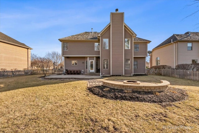 rear view of house with an outdoor fire pit, a lawn, a chimney, a fenced backyard, and a patio area