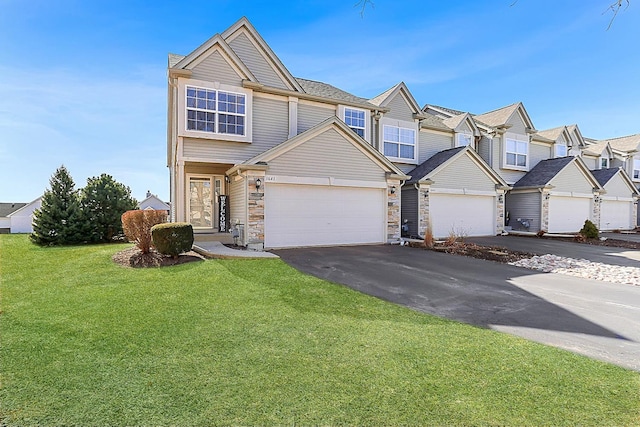 townhome / multi-family property featuring a front yard, driveway, an attached garage, stone siding, and a residential view