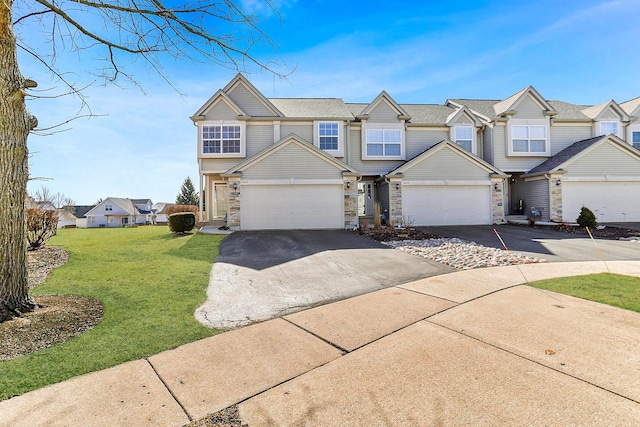 townhome / multi-family property with stone siding, driveway, and a front lawn