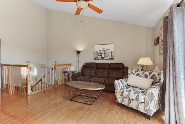 living area with high vaulted ceiling, a ceiling fan, and wood finished floors