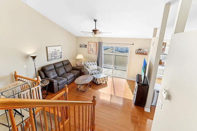 living room with baseboards, a ceiling fan, and light wood-style floors