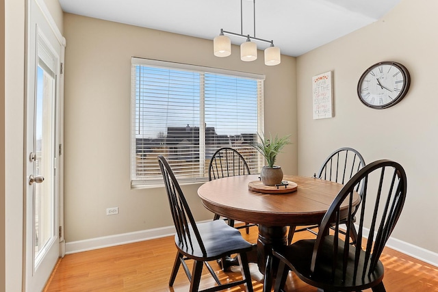 dining area featuring baseboards and light wood finished floors