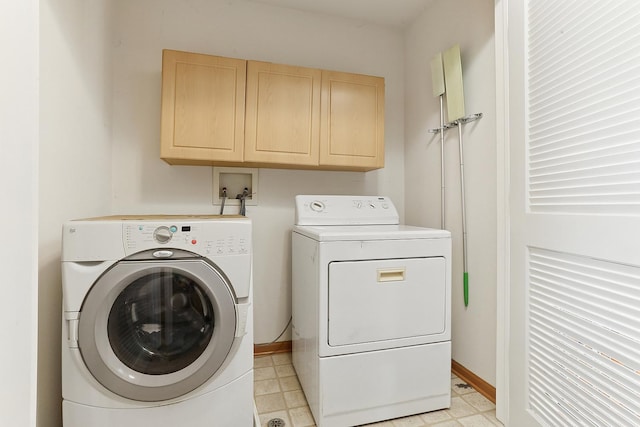 clothes washing area featuring baseboards, cabinet space, separate washer and dryer, and light floors