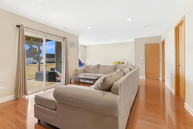 living area with recessed lighting, visible vents, baseboards, and light wood-style floors