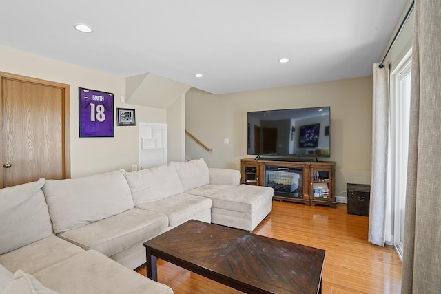 living room with recessed lighting, light wood-style floors, and stairs