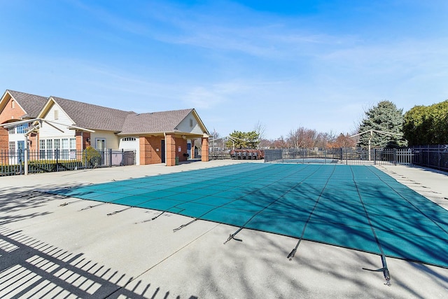 community pool with a patio and fence