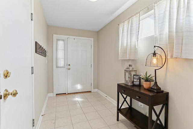 entryway with light tile patterned floors, a healthy amount of sunlight, and baseboards