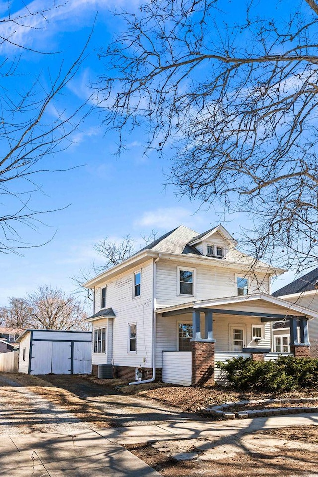 american foursquare style home featuring a porch, cooling unit, and driveway