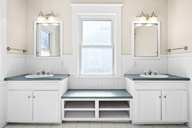 full bath with a wainscoted wall and a healthy amount of sunlight