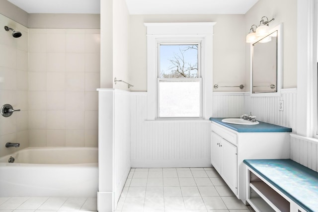 full bathroom with bathtub / shower combination, vanity, a wainscoted wall, and tile patterned flooring