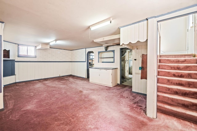 basement featuring stairway and carpet flooring