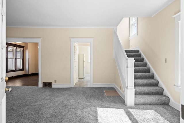 stairs featuring crown molding, baseboards, and carpet floors