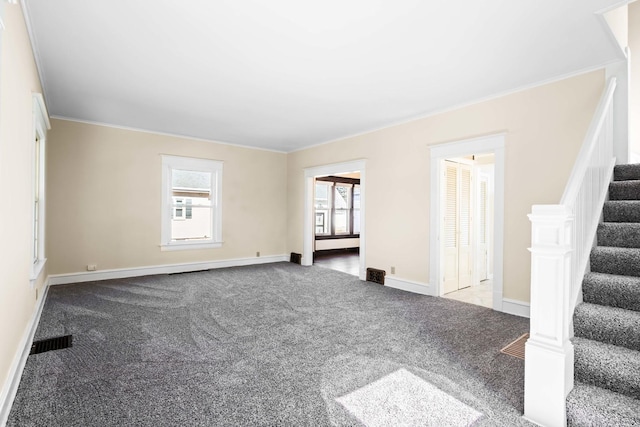 carpeted empty room with visible vents, stairs, baseboards, and ornamental molding