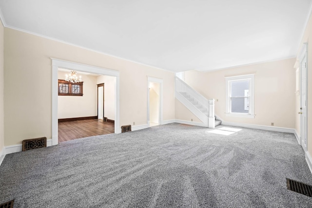 unfurnished living room with visible vents, stairs, an inviting chandelier, and carpet floors