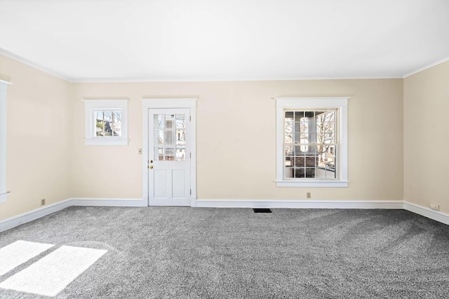 unfurnished room with visible vents, ornamental molding, baseboards, and carpet floors