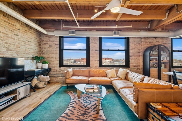 living area with visible vents, brick wall, beam ceiling, wooden ceiling, and wood finished floors