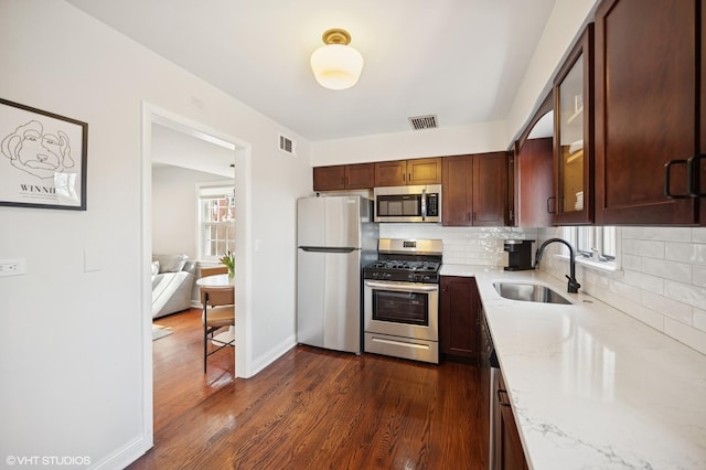 kitchen featuring light stone counters, visible vents, appliances with stainless steel finishes, and a sink