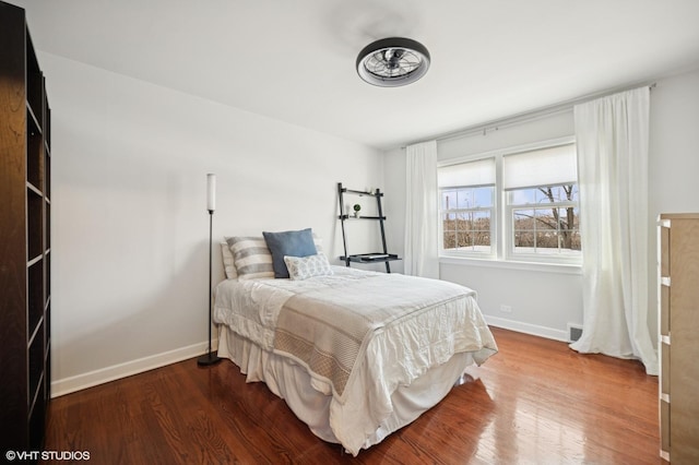 bedroom with visible vents, baseboards, and wood finished floors