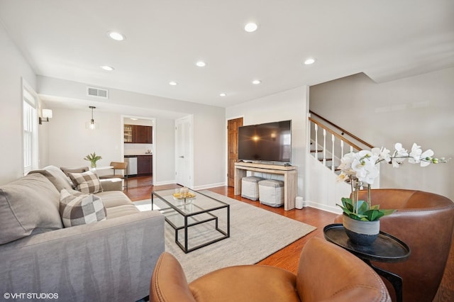 living area featuring visible vents, wood finished floors, recessed lighting, baseboards, and stairs