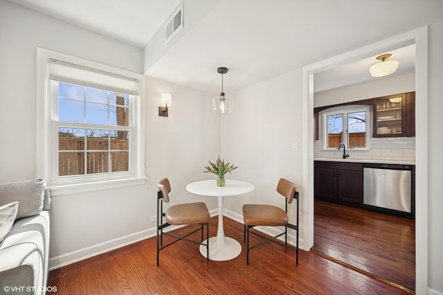 dining room featuring dark wood finished floors, baseboards, and visible vents