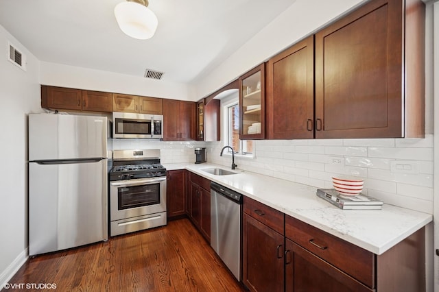 kitchen with visible vents, appliances with stainless steel finishes, dark wood-style flooring, and a sink