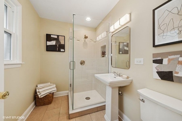 full bathroom featuring toilet, tile patterned flooring, a shower stall, and baseboards