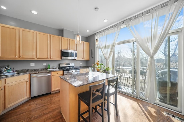 kitchen featuring a healthy amount of sunlight, light brown cabinets, stainless steel appliances, and a sink