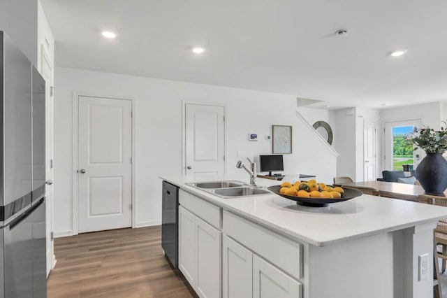 kitchen with a sink, black dishwasher, open floor plan, freestanding refrigerator, and light countertops