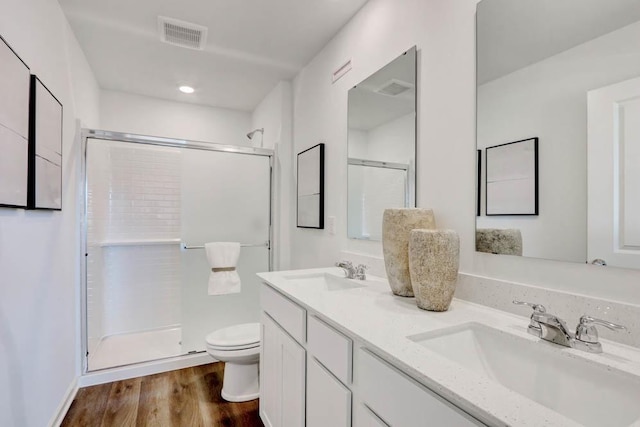 full bathroom with a stall shower, toilet, visible vents, and a sink