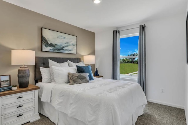 bedroom with baseboards and dark carpet