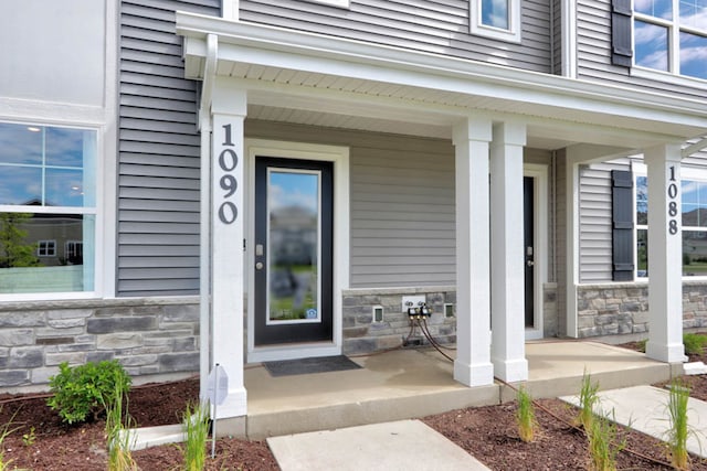 property entrance featuring stone siding and a porch