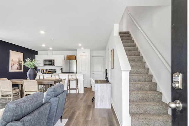 living area with stairs, recessed lighting, dark wood-style flooring, and baseboards