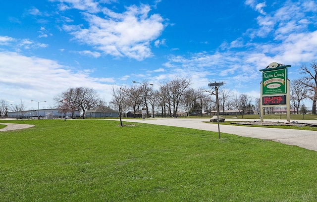 view of property's community featuring a lawn and driveway