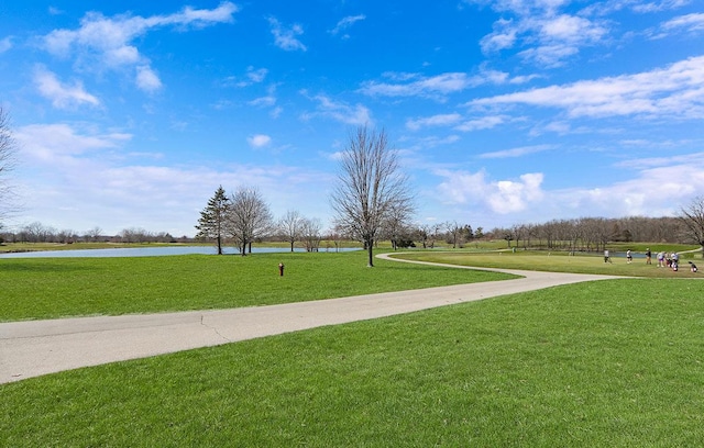 view of home's community with a water view and a lawn