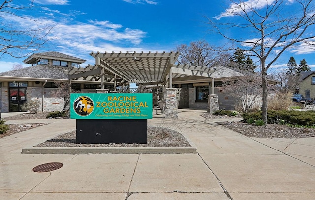 view of home's community featuring driveway and a pergola