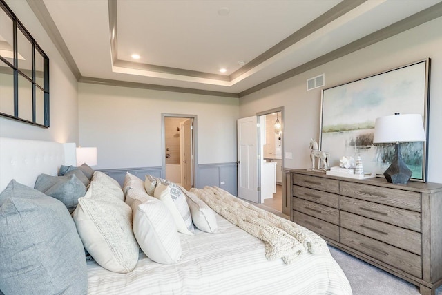 bedroom with visible vents, ensuite bathroom, recessed lighting, wainscoting, and a raised ceiling
