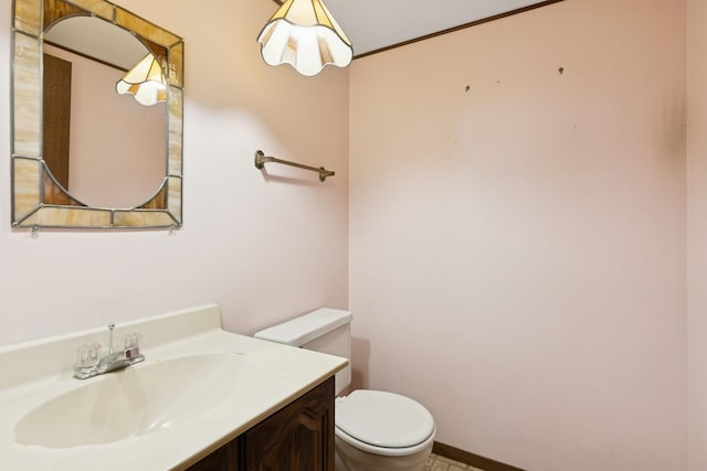 bathroom featuring toilet, vanity, and baseboards