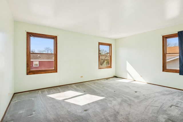 carpeted spare room featuring baseboards