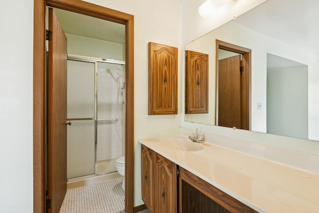 bathroom with vanity, tile patterned floors, toilet, and a stall shower