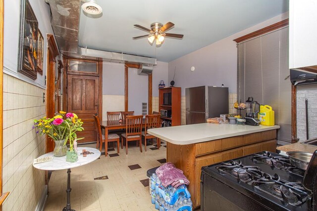 2652 W 22nd Pl, Chicago, IL 60608 - kitchen featuring gas stove, light floors, a peninsula, freestanding refrigerator, and light countertops