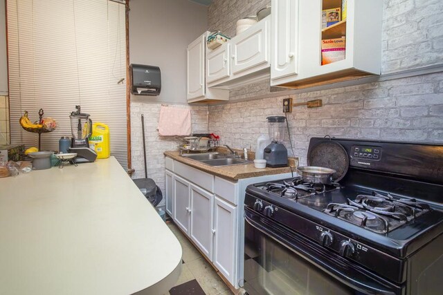 2652 W 22nd Pl, Chicago, IL 60608 - kitchen featuring black range with gas cooktop, white cabinetry, and a sink