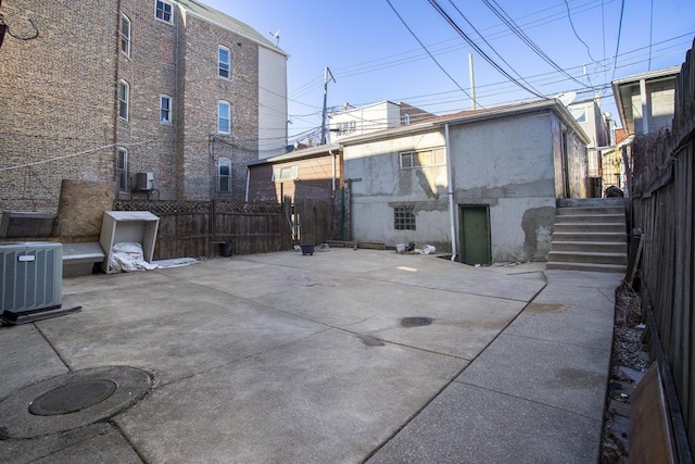 exterior space featuring central AC, stairs, and fence