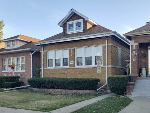 view of front facade featuring a front yard and brick siding