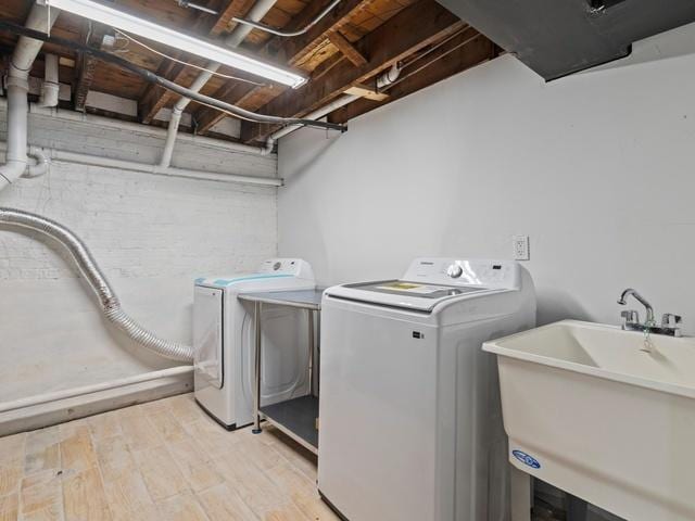 washroom with laundry area, light wood-style floors, independent washer and dryer, and a sink