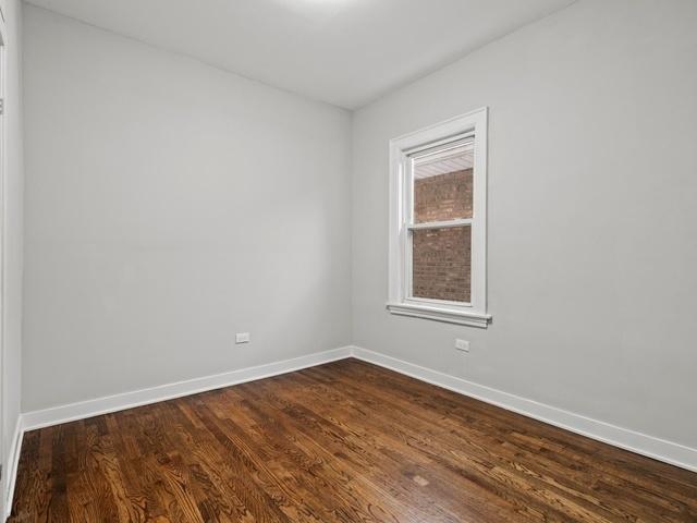 unfurnished room featuring baseboards and dark wood finished floors