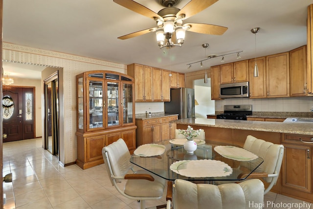 dining room with wallpapered walls, light tile patterned flooring, and ceiling fan