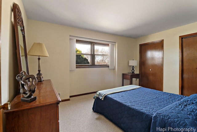 bedroom with carpet flooring, baseboards, and two closets