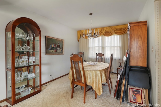 dining space with a chandelier, light carpet, and baseboards