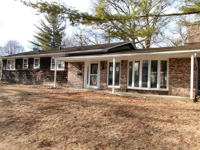 single story home with brick siding and a chimney