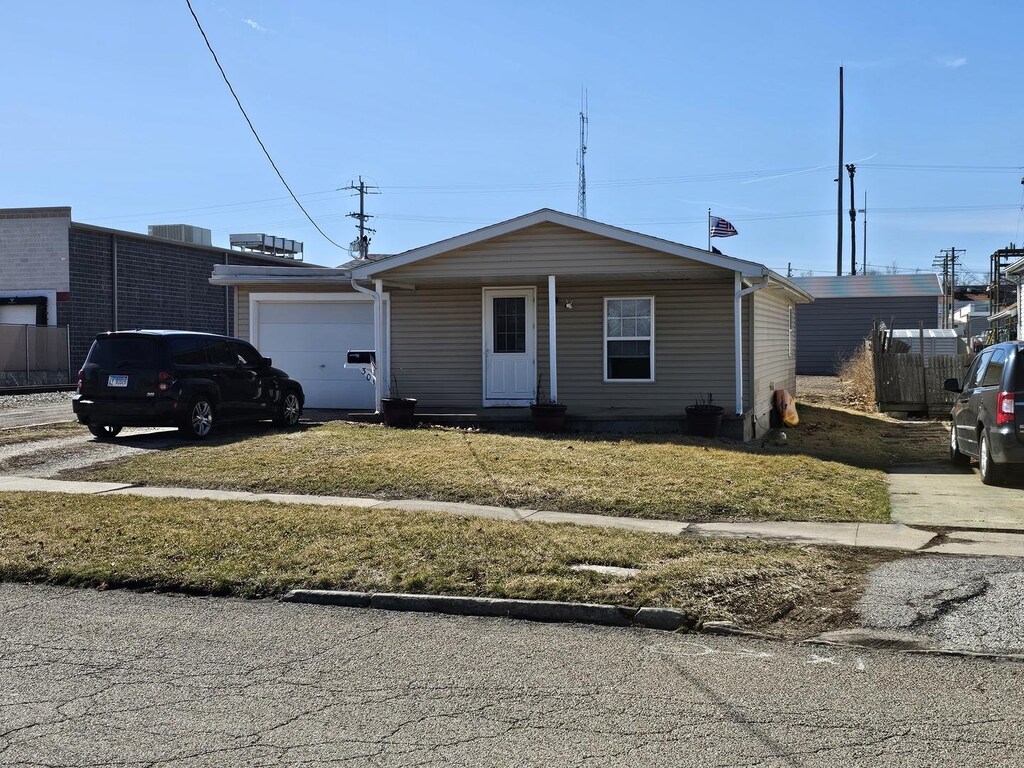 301 N Madison St, Clinton, IL 61727 - view of front facade with driveway, a front yard, and an attached garage